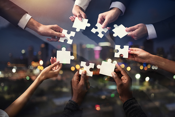 gens d'affaires qui travaillent ensemble avec des pieces de puzzles dans leurs mains, qui symbolise la parteneriat