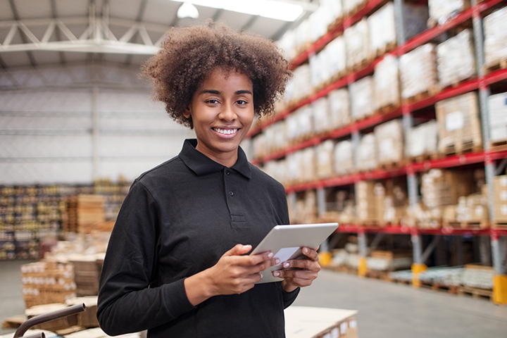 Ouvrier d'entrepôt féminin avec tablette numérique.