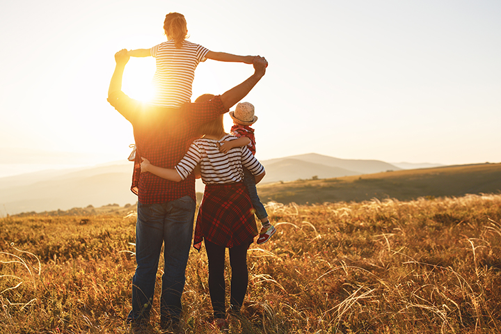 a family on a hill under the sunset