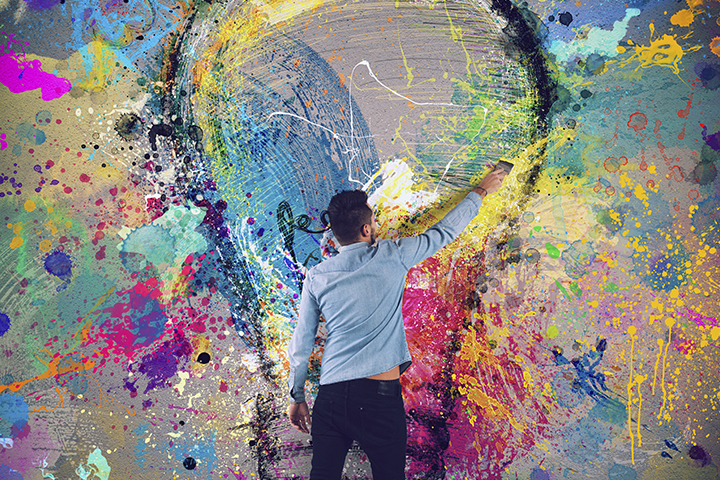 Boy draws with a brush an abstract big light bulb