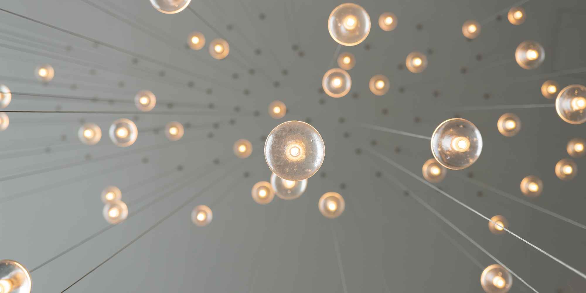 View looking directly up at lightbulbs hanging from a ceiling