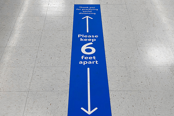 floor sticker on the ground indicating individuals to stand six feet apart