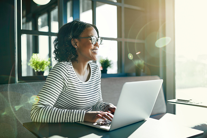 Frau mit Brille arbeitet am Laptop