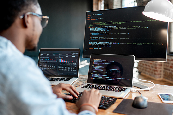 man working on his computer at his desk