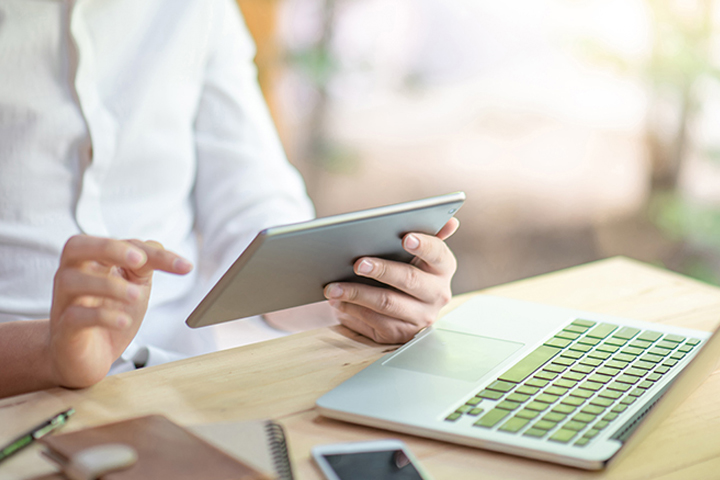 Business man using digital tablet for reading news sitting with laptop