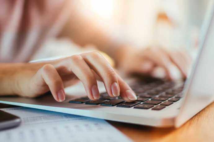 fingers typing on laptop keyboard