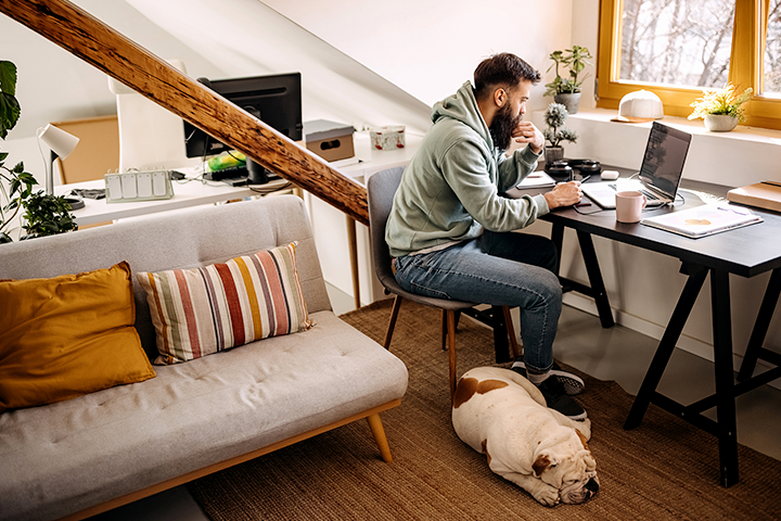 Person working from home in cozy office with dog 