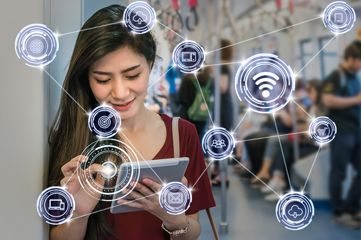 young female looking at tablet overlay of communication icons