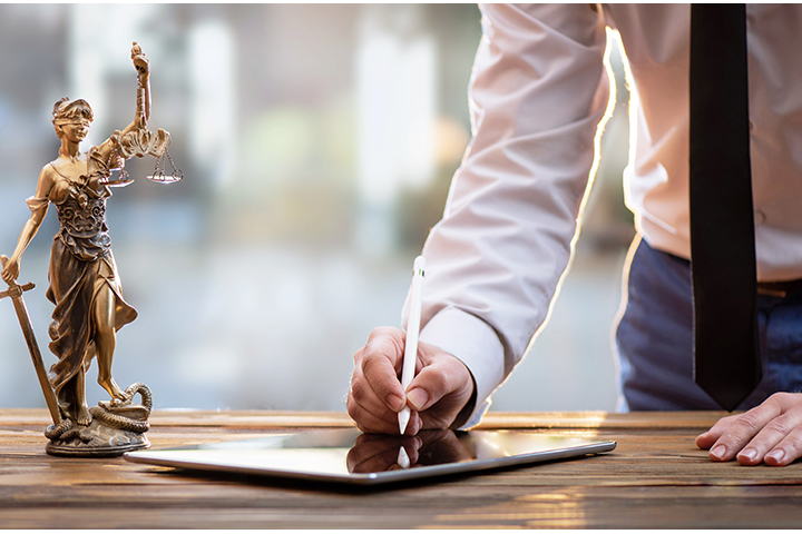 Schreibtisch mit einer Figur von Justitia, der römischen Göttin der Gerechtigkeit