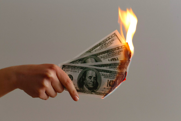hand holding burning money