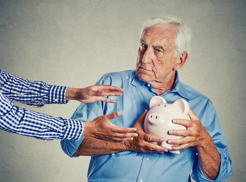 an old man holding a piggy bank