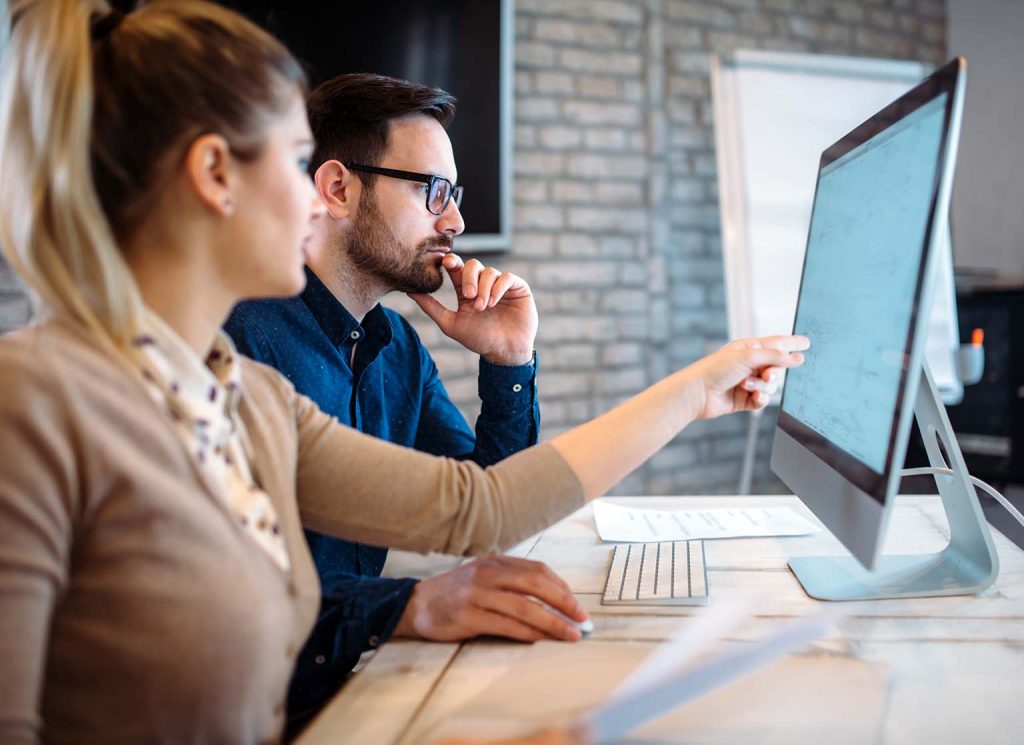 business man and woman working together at a desktop computer