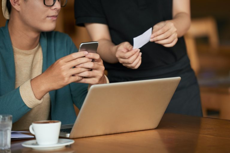 man looking at a receipt at a cafe