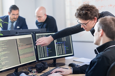 groupe de personnes qui travailent ensemble sur un projet relier a la technologie