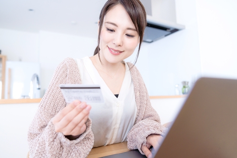 Young woman using credit card and online banking on her laptop