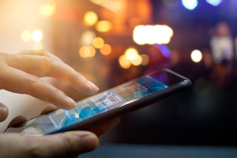 Man using mobile payments online shopping and icon on night background