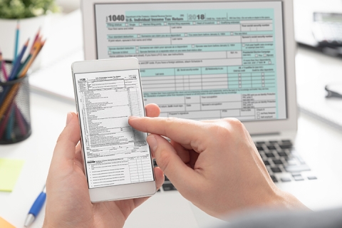 main de vue proche anonyme qui utilise son portable et son ordinateur