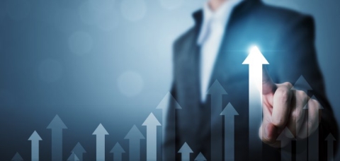 Mann im Anzug zeigt auf Pfeile 