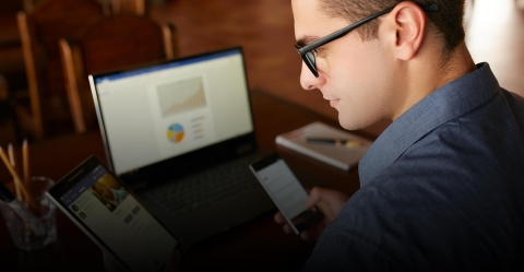 Mann mit Brille sitzt vor dem Computerbildschirm