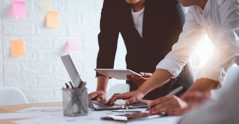 Menschen schauen im Büro auf den Laptop Bildschirm