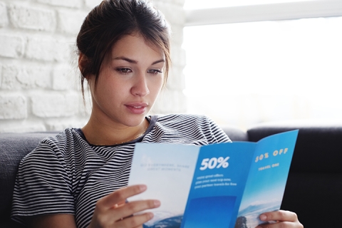 femme qui lit un brochure sur so canape