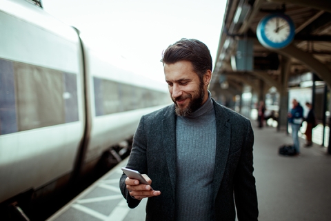 businessman using phone at rail station