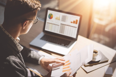 businessmen with eyeglasses working at office on laptop analyzing document