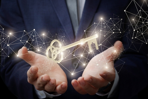 hands of an anonymous person holding a key that is glowing above their hands