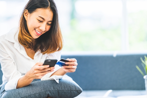 femme qui regarde son telephone sur son canape