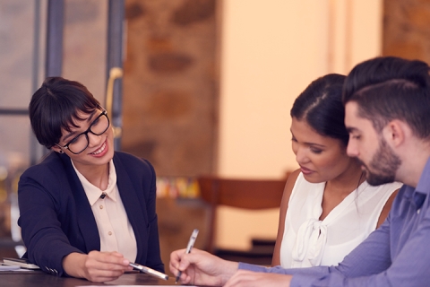 Photo d'un jeune couple rencontrant un planificateur financier dans un bureau