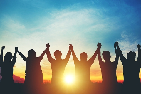 Silhouette de l'équipe commerciale du groupe faisant de hautes mains sur la tête au coucher du soleil