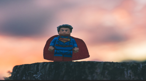 image of a lego hero toy on a cliff with sunset in background