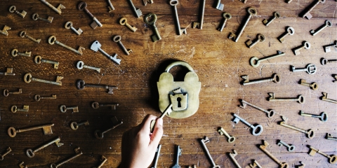 Wooden table with lock in the middle surrounded by many keys