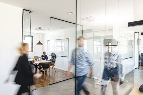 Mouvement flou d'hommes d'affaires énergiques en déplacement et de membres de l'équipe de projet discutant d'idées dans une salle de conférence.
