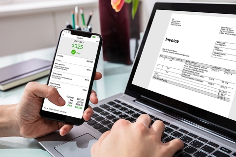 View of a smartphone and computer with invoices displayed