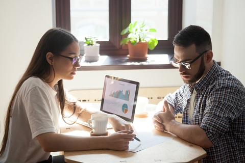 Two coworkers working together at a desk
