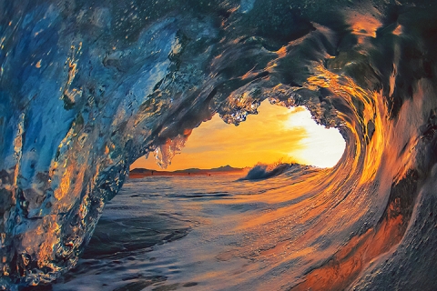 photo d'une vague dans l'océan avec le coucher du soleil en arrière-plan