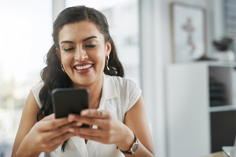 Shot of a young businesswoman using a smartphone in a modern office