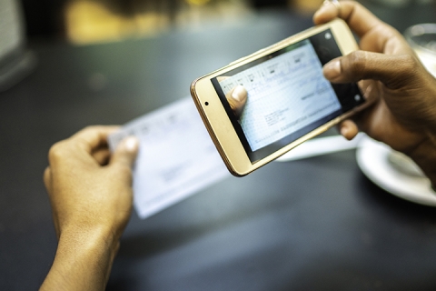 personne anonyme qui prend un photo d'un document sur son portable