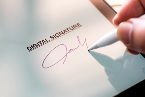 photo de quelqu'un anonyme qui ecrit son signature electronique