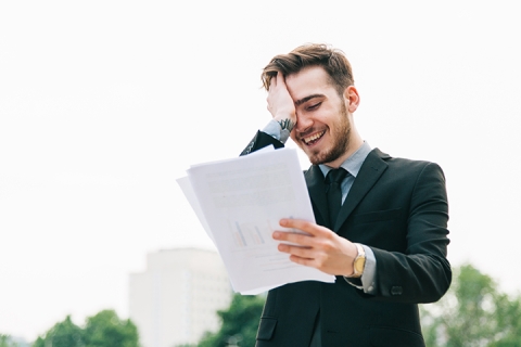 happy businessman reading something with relief or joy outside