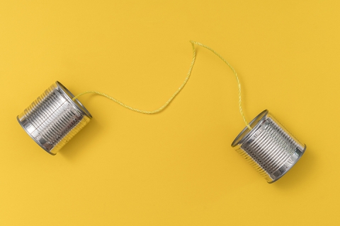 Tin can phone on yellow background