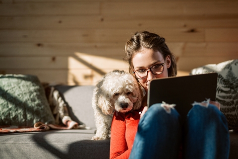 Woman and emotional support dog looking at tablet, communication