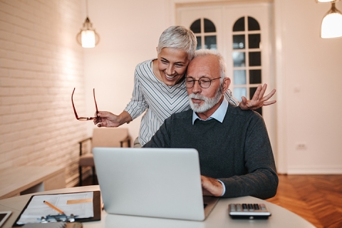man and woman viewing laptop screen