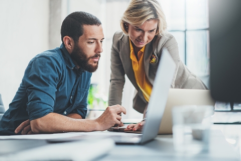 woman and man observing a computer