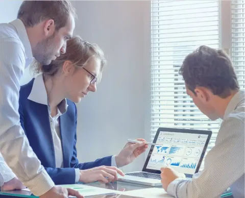 Coworkers looking at a laptop screen together