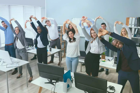 Business people stretching in unison in office