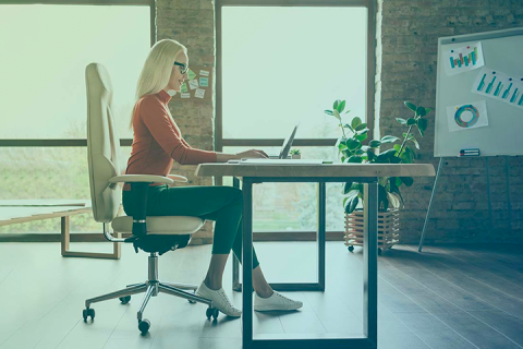 Businesswoman working at desk in middle of office