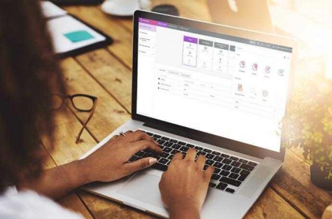 a woman typing on a macbook side view