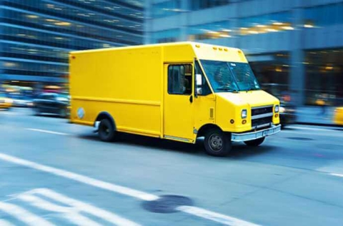 a yellow parcel van on main street
